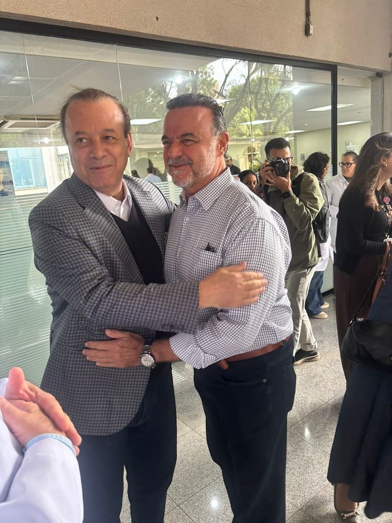Ricardo Madalena em visita a hospital, cumprimentando profissional de saúde
